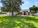 Well-maintained home with a lush green lawn, mature landscaping, and a beautiful shade tree with hanging Spanish moss at 1130 Ewell Rd, Lakeland, FL 33811
