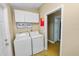 Functional laundry room with washer, dryer, and overhead storage cabinets at 1130 Ewell Rd, Lakeland, FL 33811