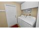 Laundry room features modern appliances, overhead cabinets, and convenient exterior access at 1130 Ewell Rd, Lakeland, FL 33811