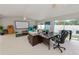 Living room with a projector screen, a ceiling fan, a desk, and access to outdoor spaces at 1130 Ewell Rd, Lakeland, FL 33811