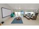 Spacious living room with a ceiling fan, a screen projector, and access to outdoor spaces at 1130 Ewell Rd, Lakeland, FL 33811