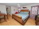 Main bedroom featuring wood floors, a ceiling fan, and a decorative wood bed frame at 1130 Ewell Rd, Lakeland, FL 33811