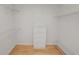 White walk-in closet features shelving, a wooden floor, and a four-drawer dresser at 1130 Ewell Rd, Lakeland, FL 33811