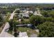 An aerial view showing a home in a neighborhood surrounded by trees and a tennis court in the distance at 1195 S 1St Ave, Bartow, FL 33830