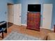 Bright blue bedroom with hardwood floors, dresser, and lots of natural light at 1195 S 1St Ave, Bartow, FL 33830