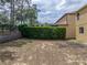 Backyard features a retaining wall and mature trees at 143 Alfani St, Davenport, FL 33896