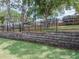A spacious backyard featuring mature trees and a retaining wall at 143 Alfani St, Davenport, FL 33896