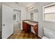 Bathroom with a wooden vanity, sink, a toilet, and an open doorway to a bedroom at 143 Alfani St, Davenport, FL 33896