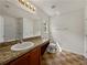 Clean bathroom features a vanity with countertop space, tiled floors, and a large mirror at 143 Alfani St, Davenport, FL 33896