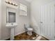 Powder room with modern pedestal sink, tiled floors, and a window for natural light at 143 Alfani St, Davenport, FL 33896