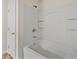 Close up on a clean white shower and tub with silver fixtures and a white door at 143 Alfani St, Davenport, FL 33896