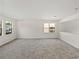 Upstairs bedroom featuring neutral carpet, light-colored walls, and windows at 143 Alfani St, Davenport, FL 33896