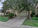 Lovely home featuring a two-car garage, driveway, and mature trees at 143 Alfani St, Davenport, FL 33896