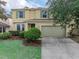 Inviting two-story home with a well-manicured lawn and attached two-car garage at 143 Alfani St, Davenport, FL 33896