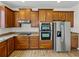 Close-up of modern kitchen featuring ample cabinets, stainless appliances and wood-look floors at 143 Alfani St, Davenport, FL 33896