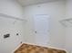 Laundry room with washer and dryer hookups, overhead shelving and tiled flooring at 143 Alfani St, Davenport, FL 33896
