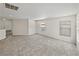 Bright, carpeted living room with neutral walls, recessed lighting, and large windows offering natural light at 143 Alfani St, Davenport, FL 33896