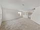 Bright living room featuring neutral carpet, light-colored walls, and large windows at 143 Alfani St, Davenport, FL 33896