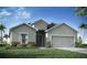 Charming one-story home featuring a symmetrical facade, complemented by a manicured lawn and lush landscaping at 1444 Fleur Dr, Davenport, FL 33837