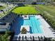 Aerial view of a luxurious community pool surrounded by lounge chairs and well-maintained landscaping at 1444 Fleur Dr, Davenport, FL 33837