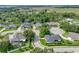 An aerial view of a single-Gathering home surrounded by lush greenery and mature trees in a residential neighborhood at 148 Melissa Trl, Auburndale, FL 33823