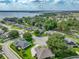 Beautiful aerial view of a home surrounded by lush greenery, other homes, and a tranquil lake at 148 Melissa Trl, Auburndale, FL 33823