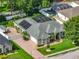 Aerial view of property with pool, screened enclosure, solar panels, brick driveway and lush landscaping at 148 Melissa Trl, Auburndale, FL 33823