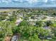 An aerial shot displays a neighborhood homes nestled among mature trees in a sunny suburban area with lakes nearby at 148 Melissa Trl, Auburndale, FL 33823