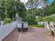 Backyard brick paved parking area with trailer, white fence perimeter, and palm trees in a sunny outdoor setting at 148 Melissa Trl, Auburndale, FL 33823