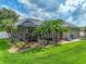 Landscaped backyard with screen enclosed pool and stone waterfall and manicured lawn at 148 Melissa Trl, Auburndale, FL 33823