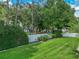 The lush green backyard features a well-manicured lawn and mature trees and privacy fence at 148 Melissa Trl, Auburndale, FL 33823
