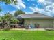 Wide backyard view featuring screened pool enclosure, with rock waterfall and green space at 148 Melissa Trl, Auburndale, FL 33823