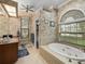 Bathroom featuring a soaking tub, tiled walls, a vanity, and a linen closet with a large window at 148 Melissa Trl, Auburndale, FL 33823