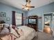 Bedroom featuring a ceiling fan, light blue walls, TV, and access to an additional bedroom at 148 Melissa Trl, Auburndale, FL 33823