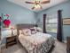 Bedroom featuring a ceiling fan, light blue walls, a grey headboard, and two windows at 148 Melissa Trl, Auburndale, FL 33823