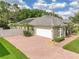 Charming exterior of home with brick driveway, well-manicured lawn, and lovely landscaping at 148 Melissa Trl, Auburndale, FL 33823