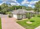 Expansive view of home exterior highlighting the brick driveway, manicured lawn, and mature trees at 148 Melissa Trl, Auburndale, FL 33823
