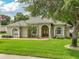 Beautiful single-story home with lush green lawn, brick walkway and mature landscaping at 148 Melissa Trl, Auburndale, FL 33823