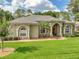 Well-maintained single-story home with brick walkway, arched entry, and lush green lawn at 148 Melissa Trl, Auburndale, FL 33823