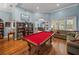 The game room features a red billiards table, a sitting area, and a view of the pool area at 148 Melissa Trl, Auburndale, FL 33823