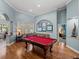 This game room features a red felt billiards table, stylish decor, and beautiful hardwood floors at 148 Melissa Trl, Auburndale, FL 33823