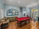 View of the game room with a billiards table, an elegant light fixture, and access to the front entry at 148 Melissa Trl, Auburndale, FL 33823