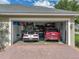 Spacious garage featuring two vehicles, storage cabinets, and a well-organized layout for functionality and convenience at 148 Melissa Trl, Auburndale, FL 33823
