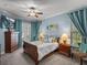 Relaxing main bedroom with a ceiling fan, light blue walls, outdoor access, and warm wood furniture at 148 Melissa Trl, Auburndale, FL 33823
