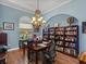 This home office features wood floors, blue walls, and a decorative chandelier at 148 Melissa Trl, Auburndale, FL 33823