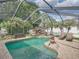 Inviting screened-in pool area featuring a rock waterfall and a spacious patio at 148 Melissa Trl, Auburndale, FL 33823