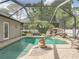 Beautiful screened in pool with a rock waterfall feature and well-maintained brick patio at 148 Melissa Trl, Auburndale, FL 33823