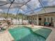Inviting screened pool area with rock waterfall, lounge chairs, and outdoor seating at 148 Melissa Trl, Auburndale, FL 33823