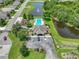 Aerial view showcasing the community pool, playground, and clubhouse nestled among trees and a pond at 1547 Cordgrass Way, Lakeland, FL 33813