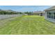 The home's expansive backyard features a well-manicured lawn and white fencing for privacy and security at 1547 Cordgrass Way, Lakeland, FL 33813